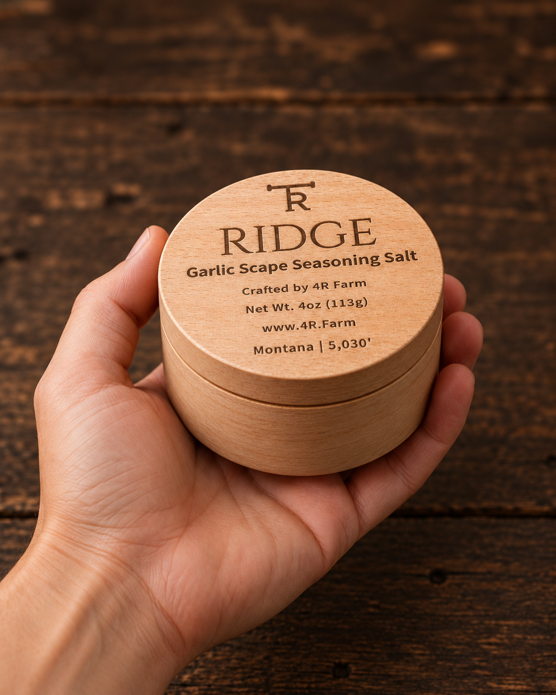 Hand holding a four-ounce RIDGE salt beechwood tin for scale.