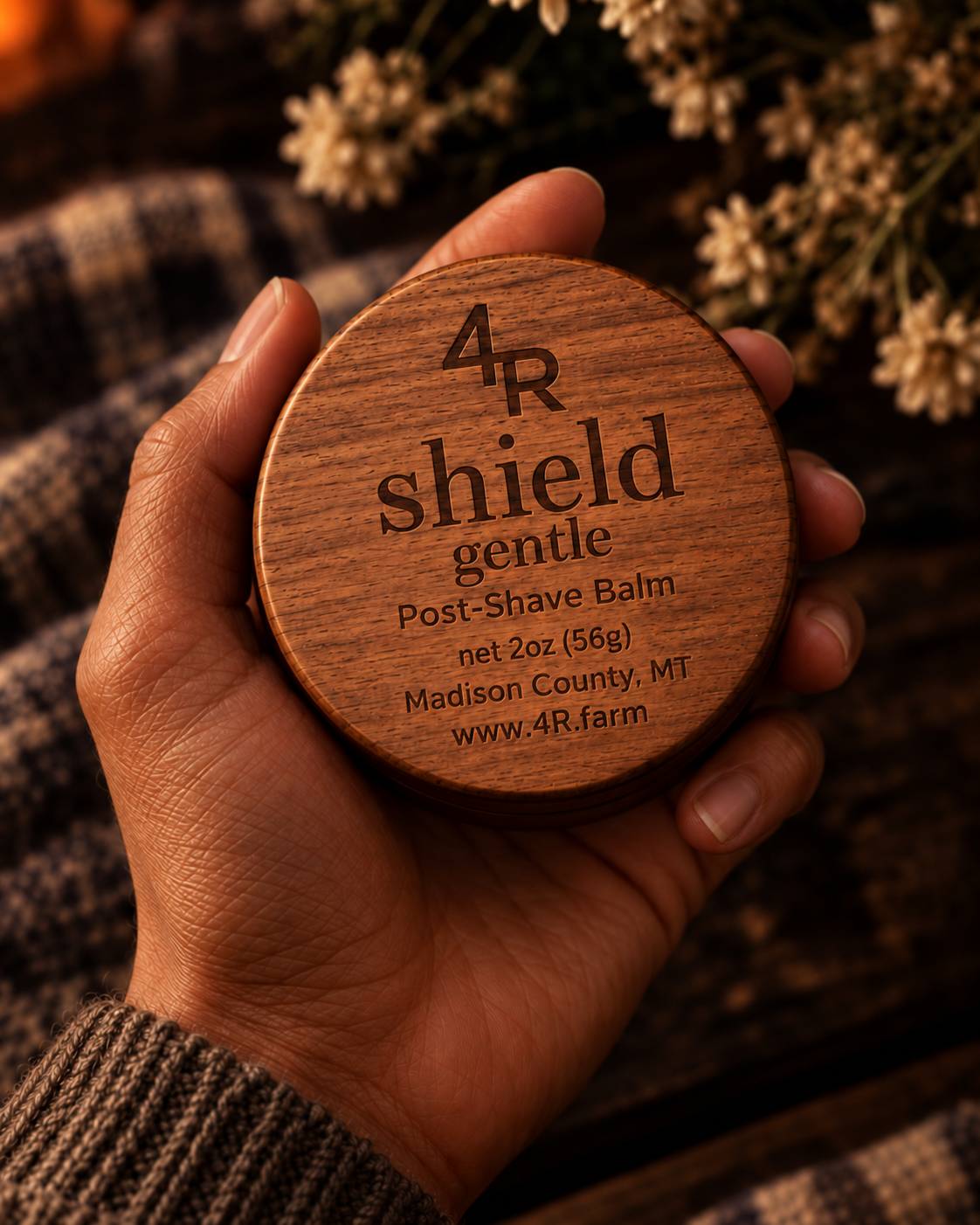 Hand holding SHIELD GENTLE Soothing Post-Shave Balm in its walnut-lidded tin