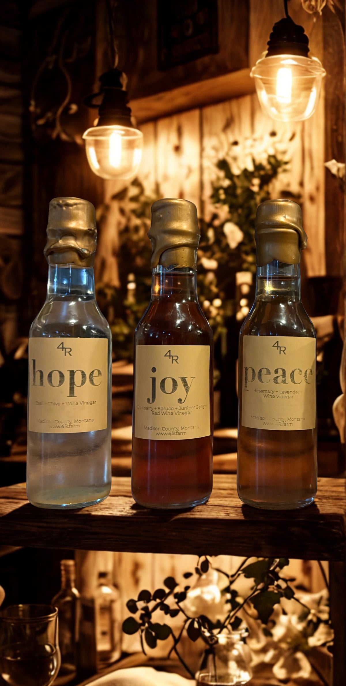 Three bottles labeled 'hope', 'joy', and 'peace' on a wooden surface with warm lighting.