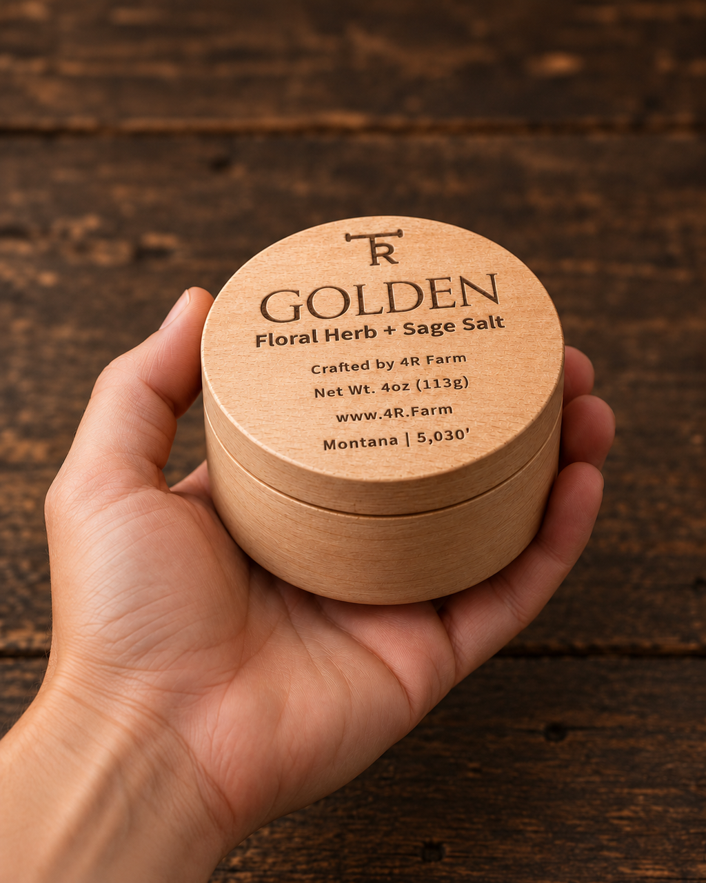Hand holding a four-ounce GOLDEN salt beechwood tin for scale.
