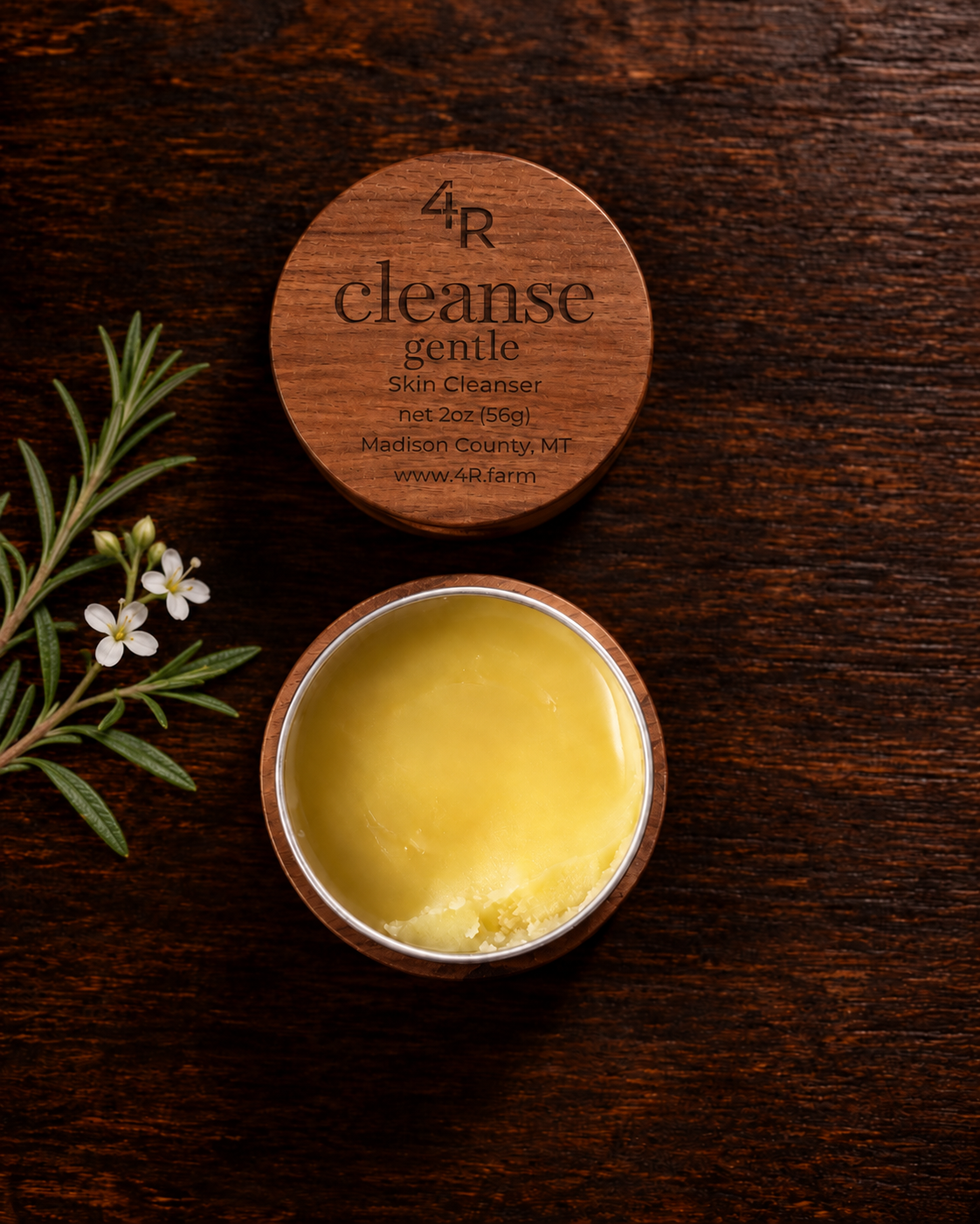 Open CLEANSE GENTLE Daily Facial Cleanser beside its walnut lid on dark wood