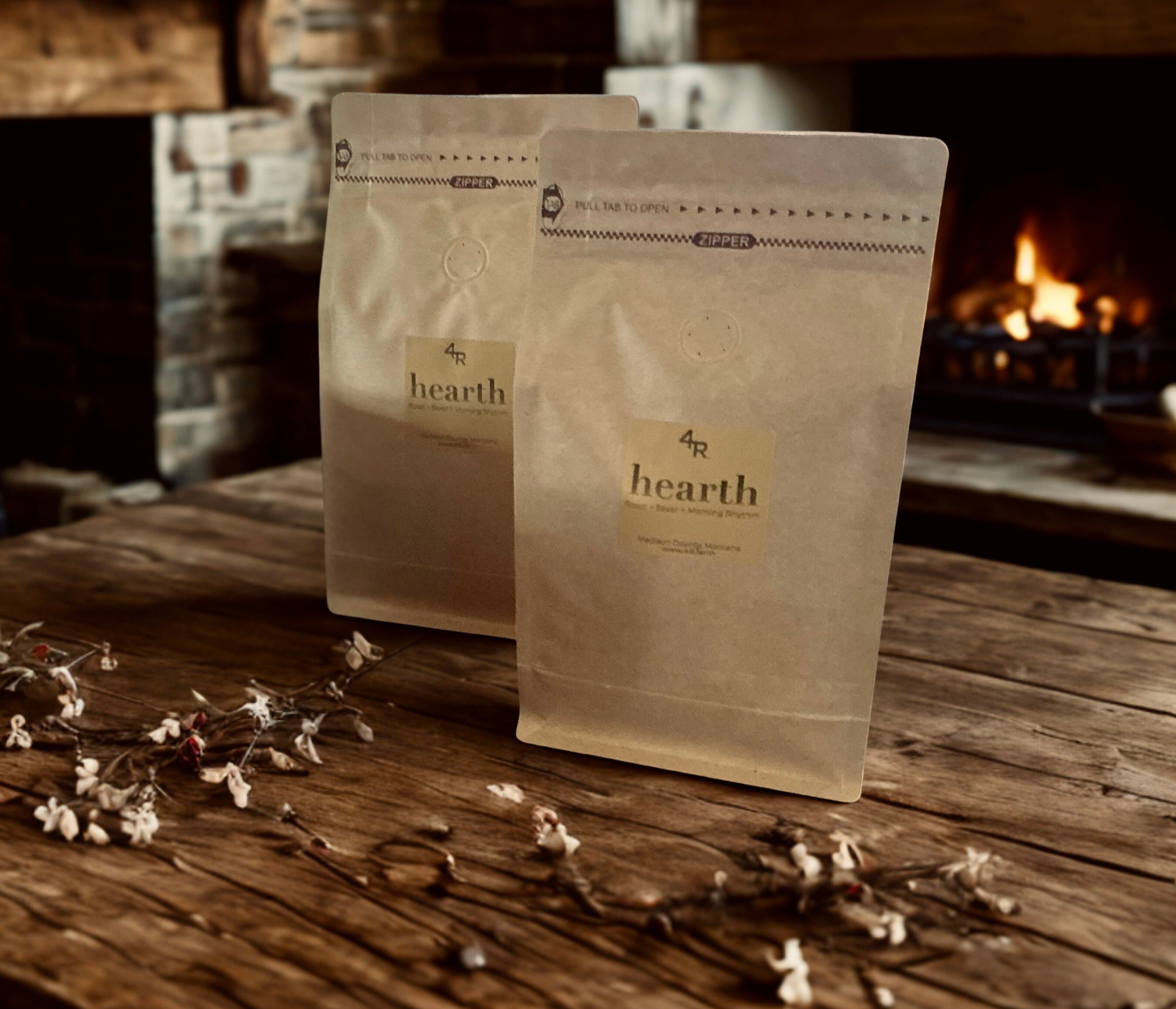 Two 'hearth' coffee bags on a wooden surface with a fireplace in the background