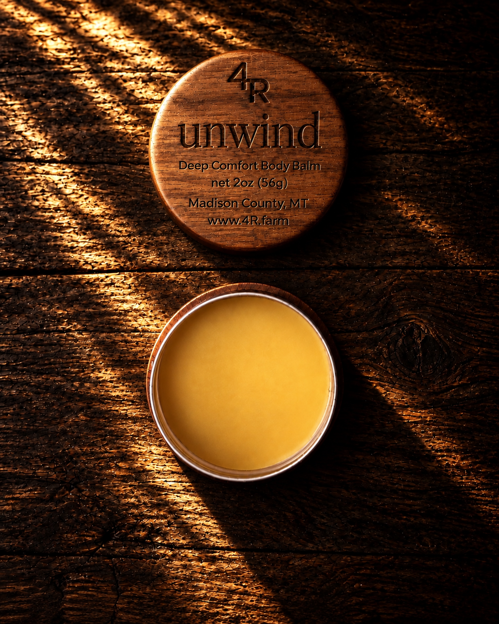 Open UNWIND Deep Comfort Body Balm beside its engraved walnut lid.