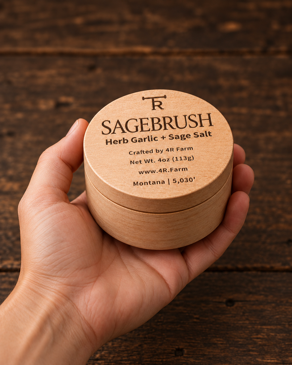Hand holding a four-ounce SAGEBRUSH salt beechwood tin for scale.