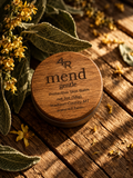 MEND GENTLE Protective Skin Balm in a walnut-lidded tin with botanicals on dark wood