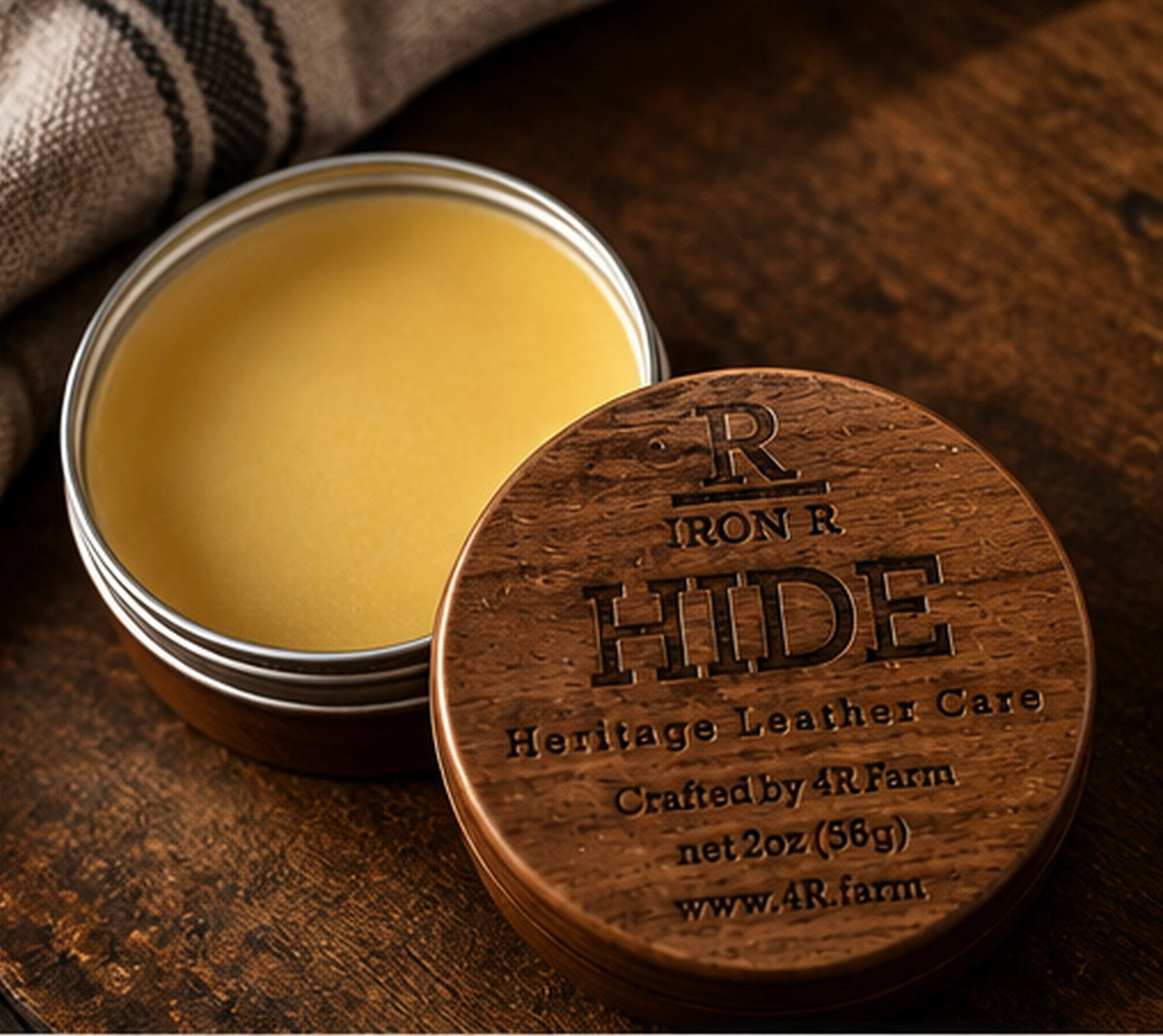 Open tin of IRON R HIDE Heritage Leather Care beside its engraved walnut lid.