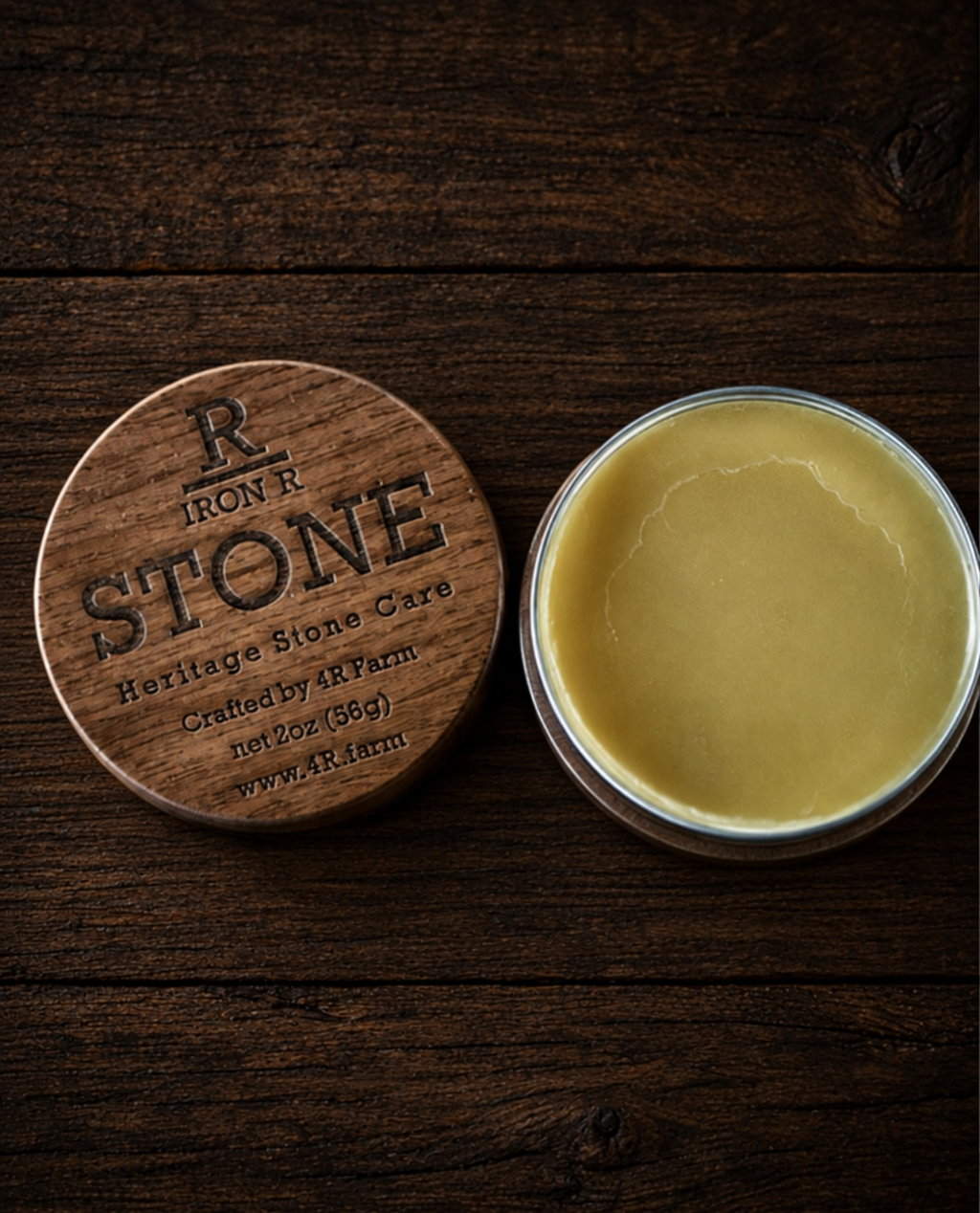 Open tin of IRON R STONE Heritage Stone Care beside its engraved walnut lid.