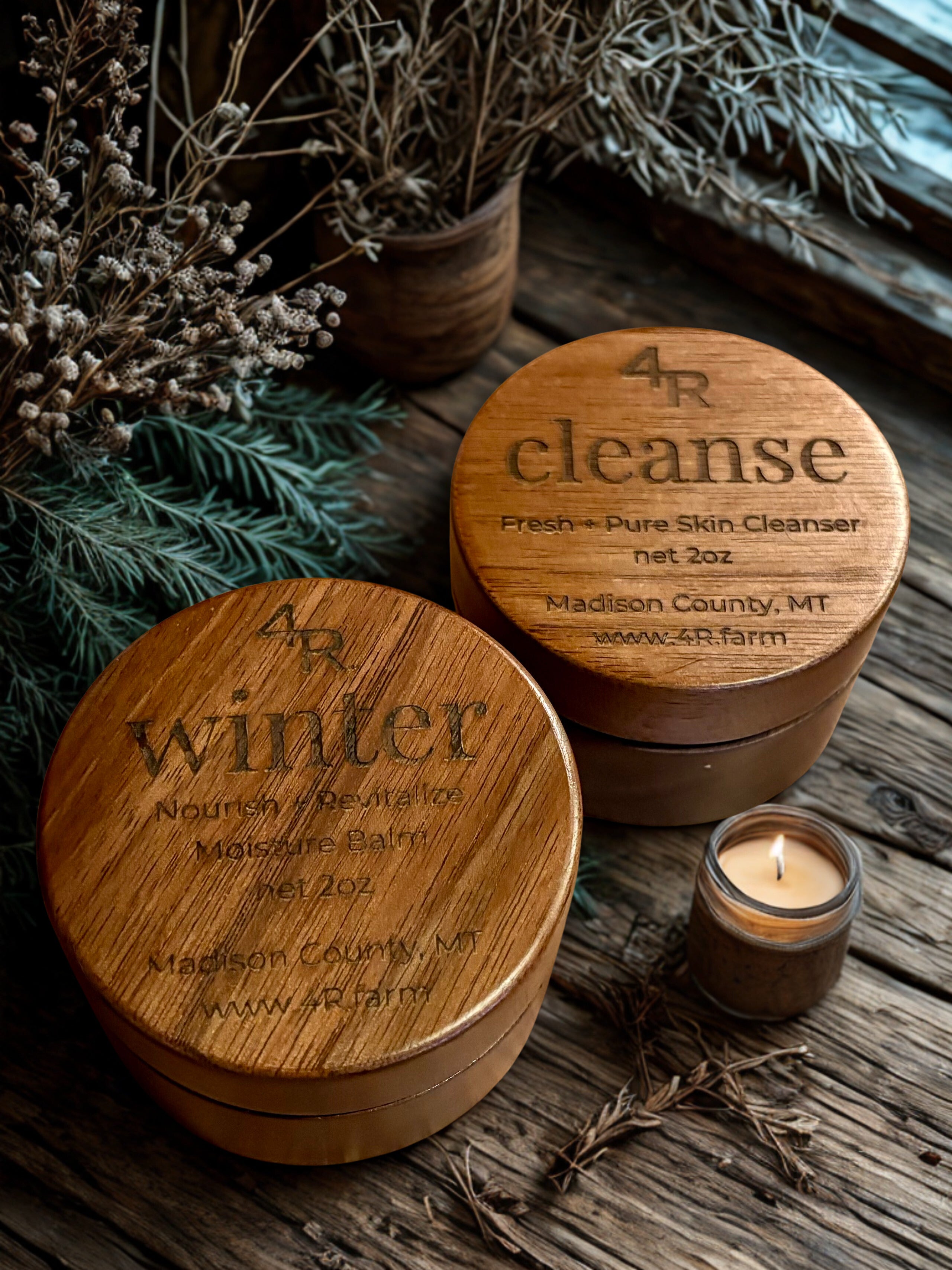 Wooden containers labeled '4R cleanse' and 'winter' on a rustic wooden surface with a candle.