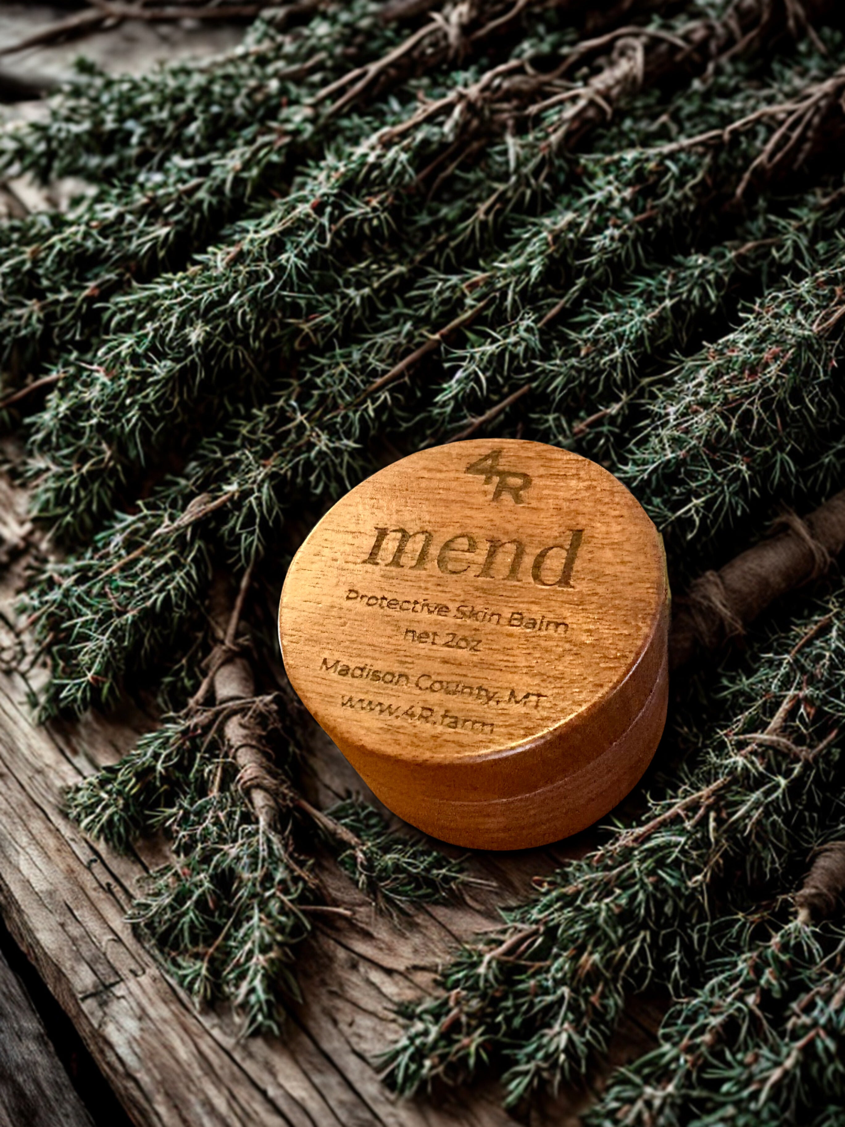 Wooden container labeled 'mend' on a rustic background with greenery