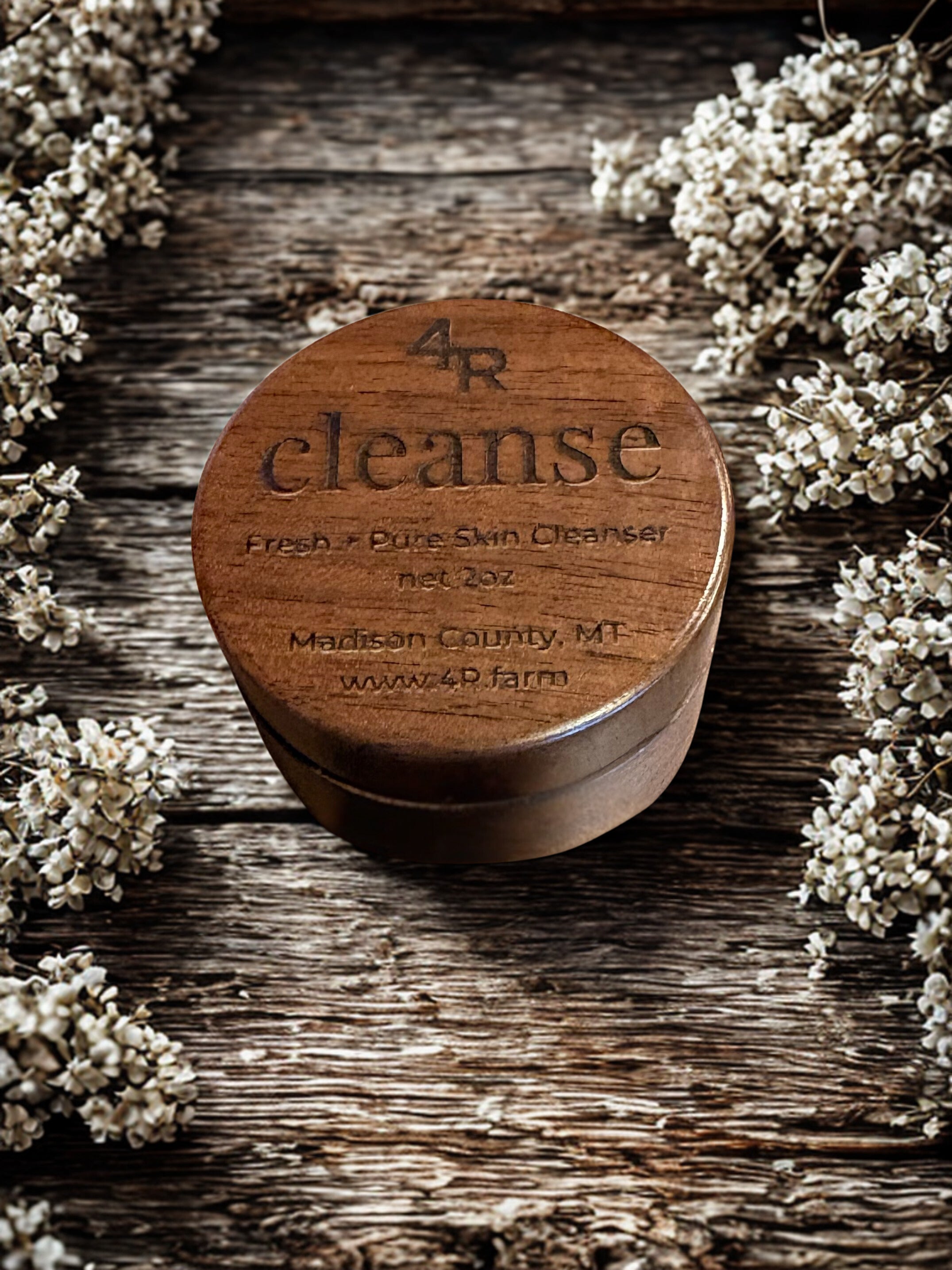 Wooden container labeled '4R cleanse' on a wooden surface with flowers around