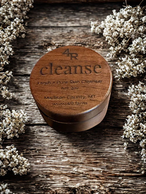 Wooden container labeled '4R cleanse' on a wooden surface with flowers around