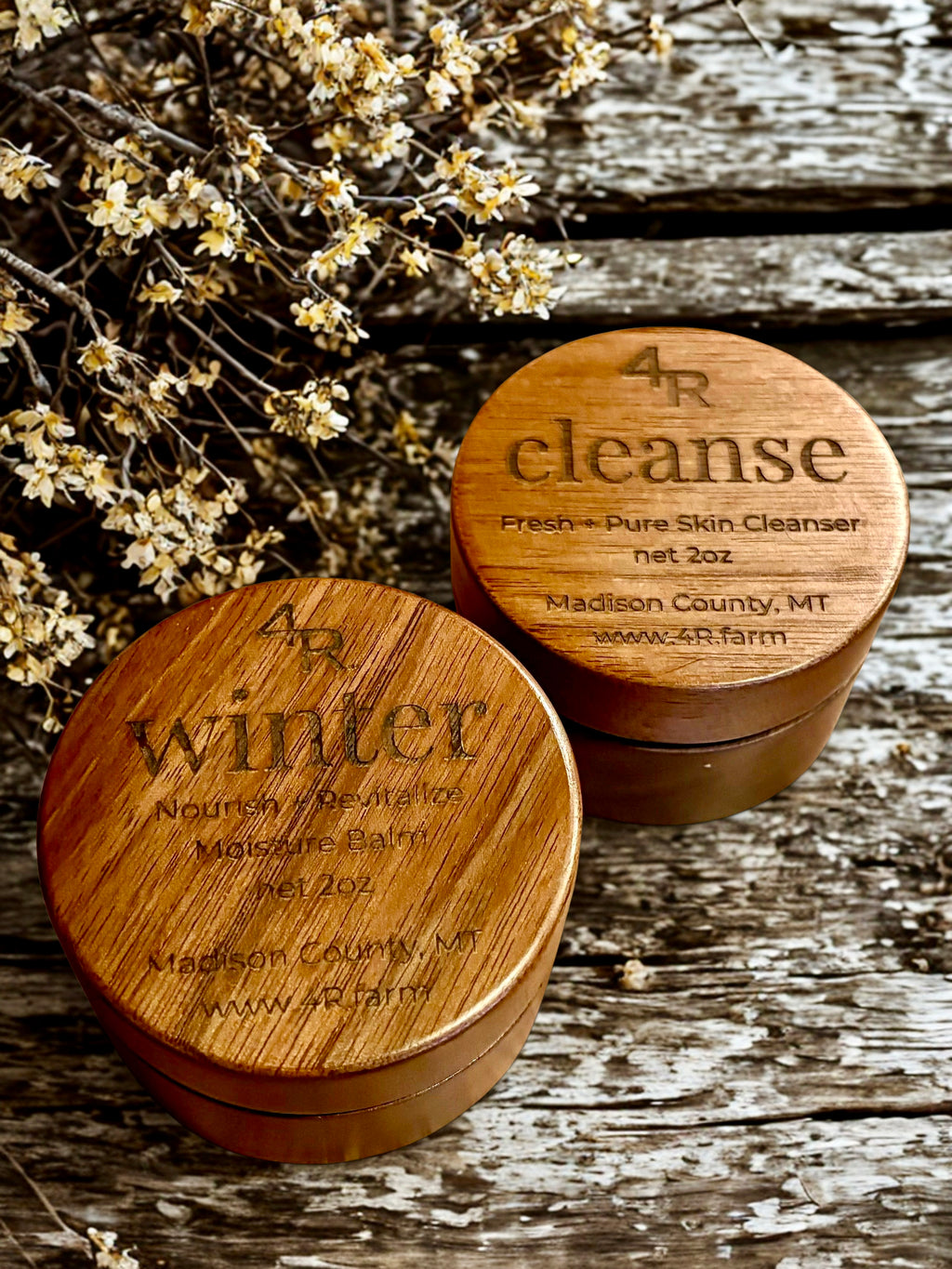 Two wooden containers labeled '4R cleanse' and '4R winter' on a rustic wooden surface with flowers.