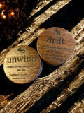 Two wooden containers labeled 'unwind' and 'drift' on a wooden surface.