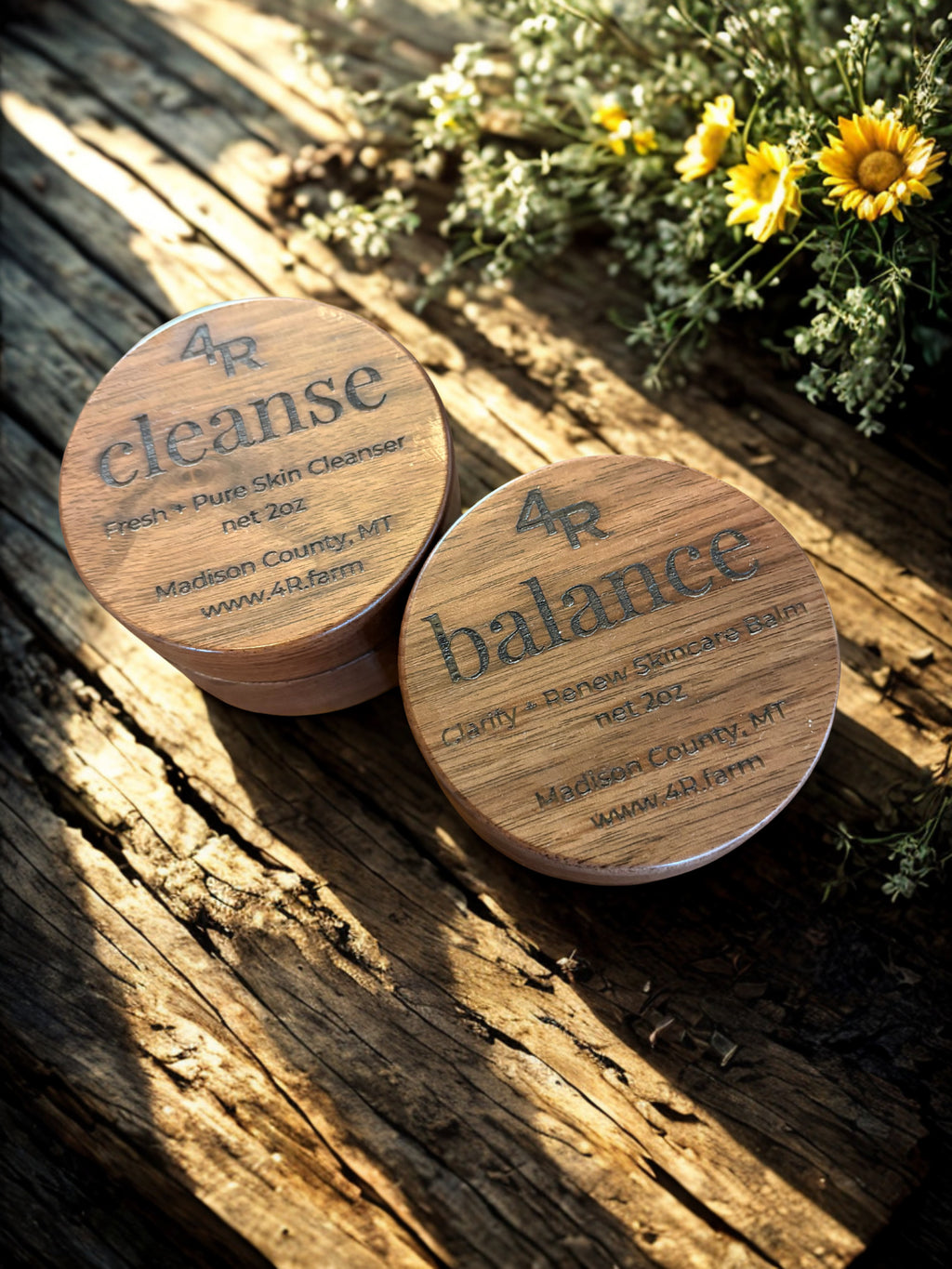 Two wooden containers labeled '4R cleanse' and '4R balance' on a wooden surface with flowers in the background.