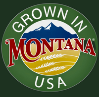 Round logo with ‘grown in Montana’ written on a background of mountains and wheat fields.