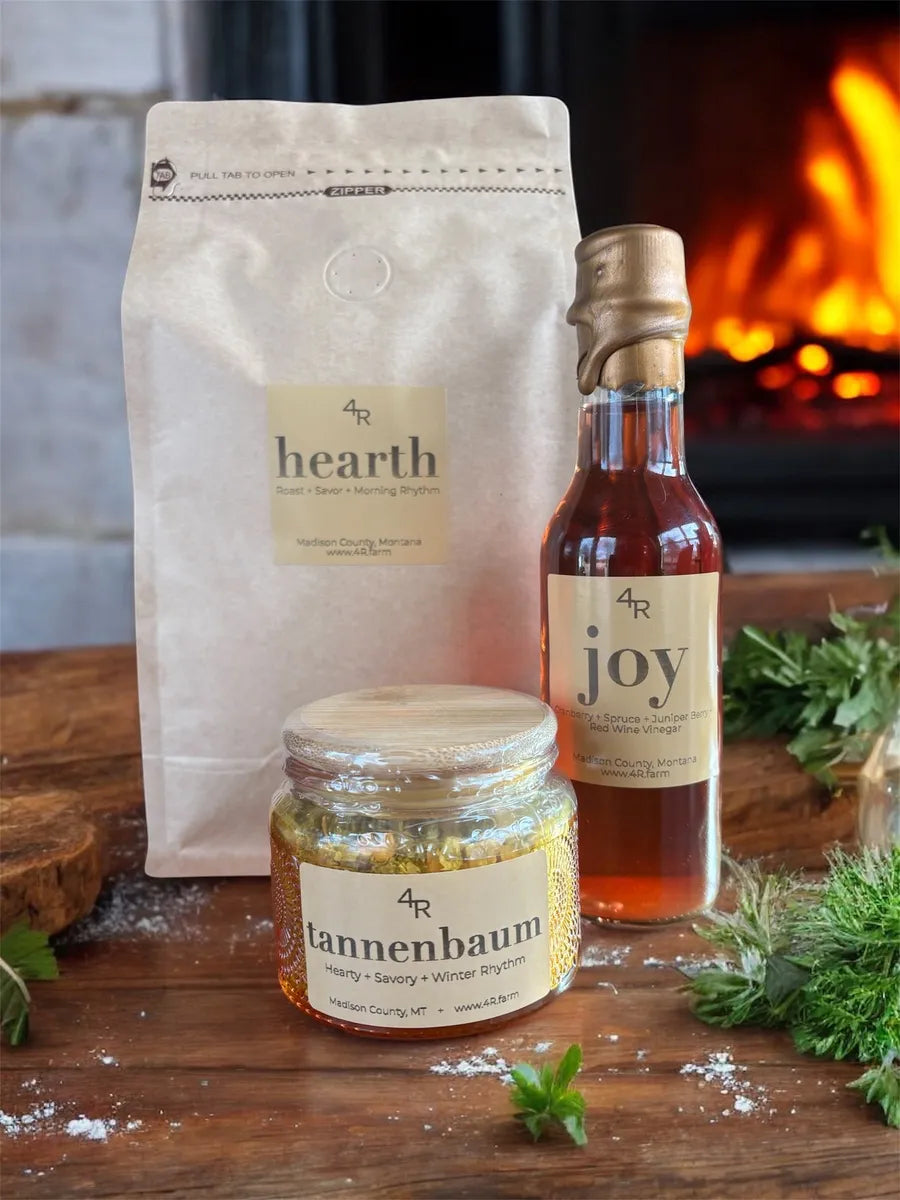 Three products labeled 'hearth', 'joy', and 'tannenbaum' on a wooden surface with a fireplace in the background.