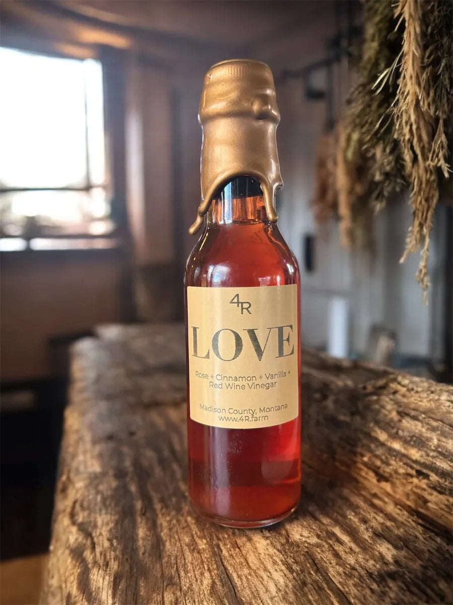 Bottle of 4R Love red wine vinegar on a wooden surface with a blurred background